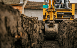 Cropped picture of a backhoe digging soil and making foundation at construction site