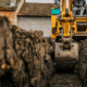 Cropped picture of a backhoe digging soil and making foundation at construction site