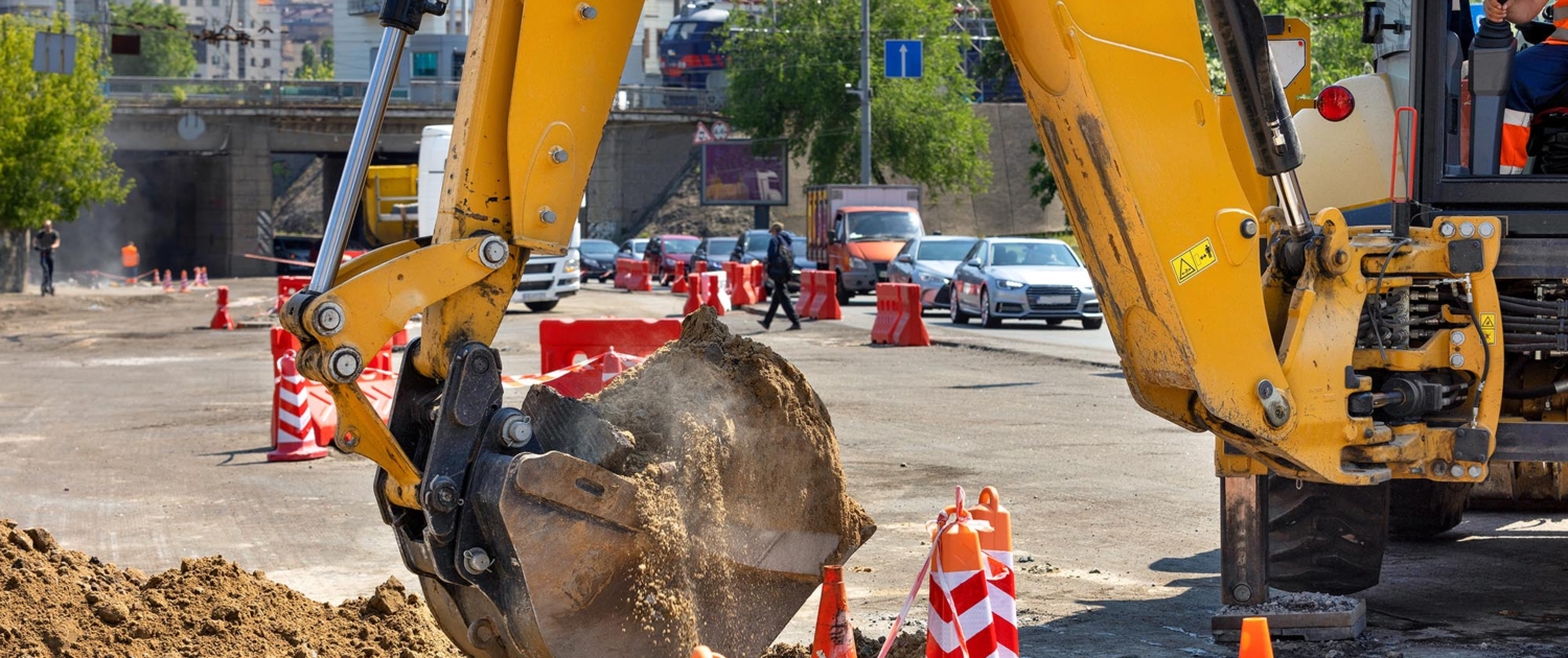 Side view of an excavator digging at a construction site