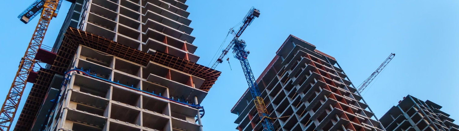 Worm's eye view of construction being done on multiple high rise buildings