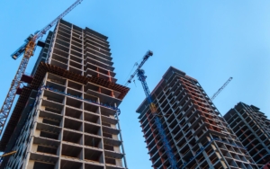 Worm's eye view of construction being done on multiple high rise buildings