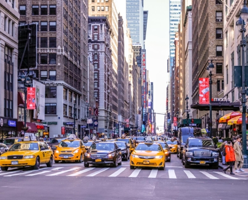 Front view of a New York City street lined with high rise buildings