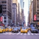 Front view of a New York City street lined with high rise buildings