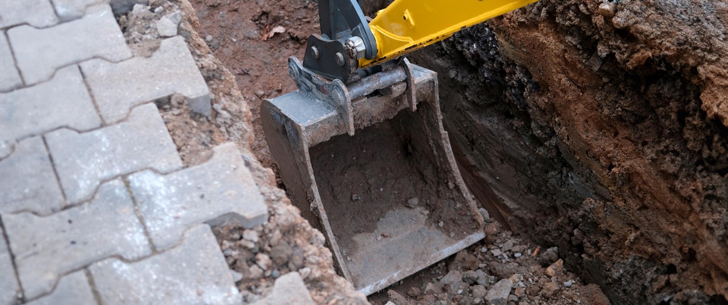 Side view of an excavator digging under a street